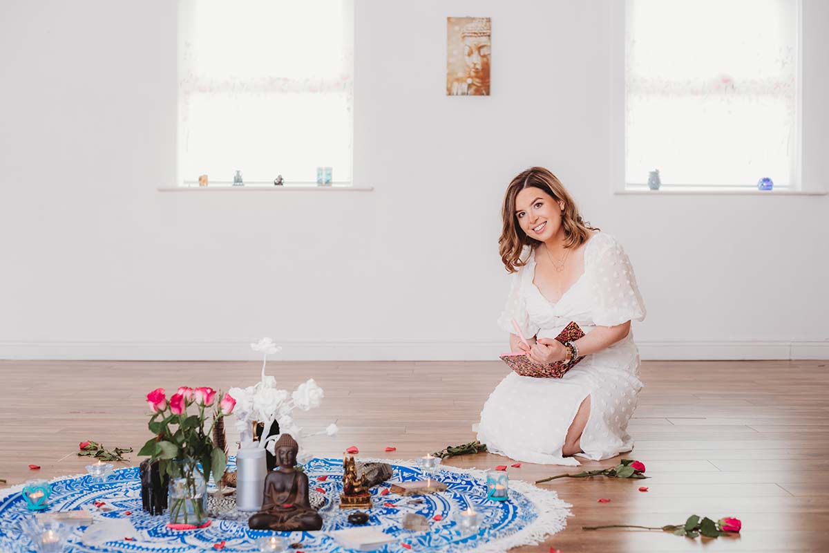 woman kneeling in front of spiritual alter with flowers